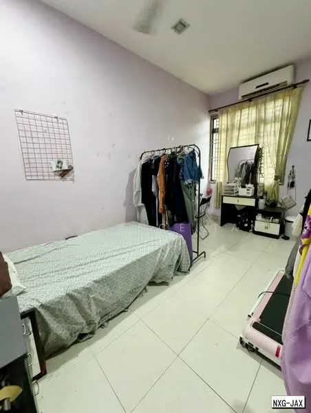 Bedroom features: single bed with bedding, light purple painted walls, white tiled flooring, window with sheer curtains, wall-mounted air conditioning unit, clothing rack with hanging clothes, dressing table with mirror, exercise equipment, decorative wall grid, ceiling fan.