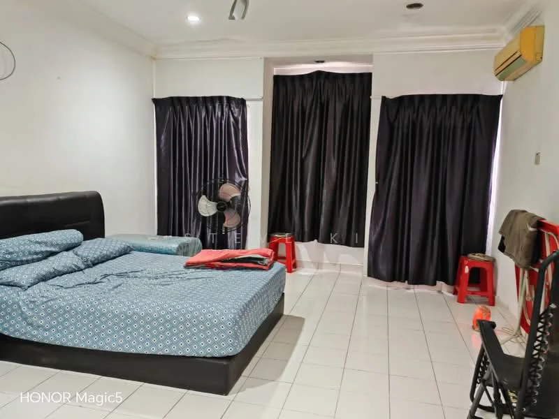 Bedroom features: king-size bed with patterned bedding, black upholstered headboard, white walls, tile flooring, two large windows with black curtains, ceiling-mounted air conditioning unit, standing fan, red plastic stools, black wooden chair, decorative wall molding; style: modern.