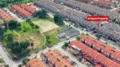 Exterior type: linked terrace house; features: red tiled roof, two-storey buildings, manicured lawn, green park area, surrounding residential neighborhood, paved walkways, open green space, parking spaces visible; style: modern.