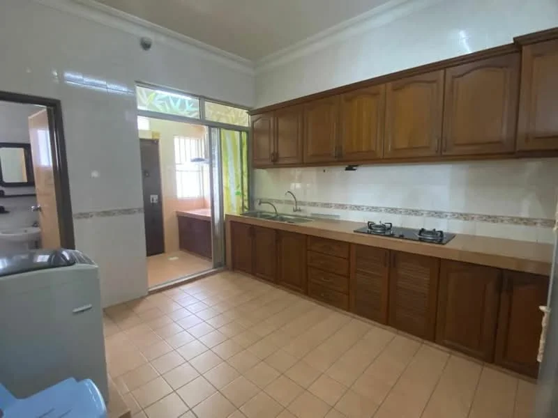 Kitchen features: brown wooden cabinetry, double-bowl stainless-steel sink, chrome pull-down faucet, 2-burner gas hob, ceramic tile backsplash, cream tiled walls, tan ceramic tile flooring, window with sheer curtains, door leading to another room, countertop with storage below; style: traditional.