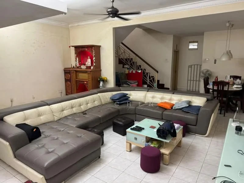 Living features: L-shape sectional sofa in grey and cream, coffee table with wooden top, tile flooring, white painted walls, ceiling fan, wall-mounted decorative shelf, staircase leading to upper floor, dining area visible in background with wooden dining table, decorative altar in red cabinet, multiple throw pillows on sofa, open layout connecting to dining area; style: modern.