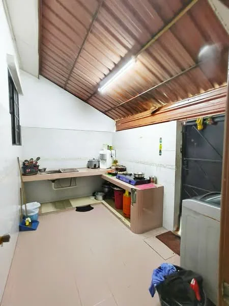 Kitchen features: white painted walls, brown metal roof, tile flooring, single-bowl stainless-steel sink, chrome pull-down faucet, countertop with beige finish, kitchen cabinets in light color, stainless-steel refrigerator, washing machine, various kitchen utensils and containers, open shelving, window with black frame.