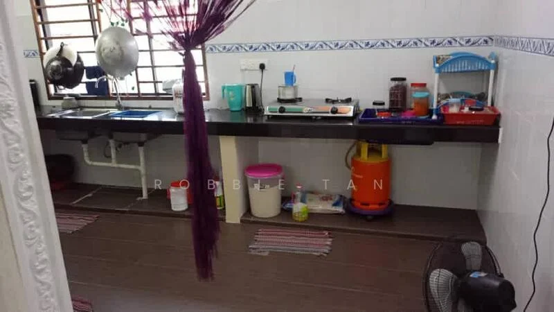 Kitchen features: black countertop, white tiled backsplash, stainless-steel sink, chrome faucet, gas stove, kettle, plastic storage containers, various cooking utensils, floor-mounted cabinets, wooden flooring, wall-mounted shelves, fan.