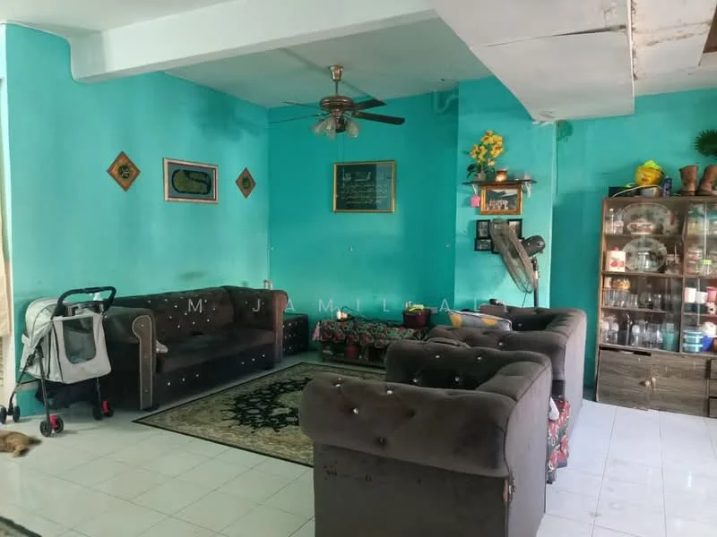 Living features: turquoise painted walls, white tiled flooring, 5-blade ceiling fan, 3-seater fabric sofa in dark brown, 2-seater fabric sofa in dark brown, area rug with floral pattern, wooden display cabinet with glass doors, decorative wall art, potted plants, baby stroller, wall-mounted chalkboard; style: traditional.