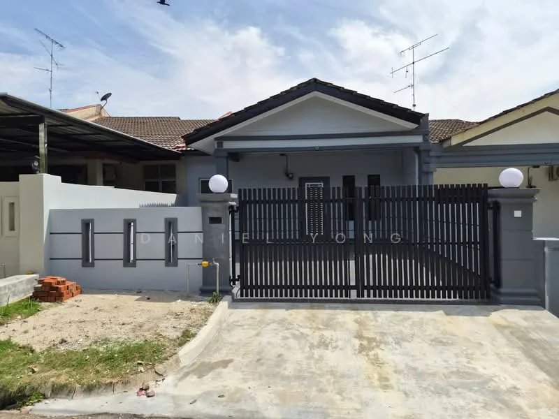 Exterior type: semi-detached house; features: grey painted facade, black wooden gate, white round lamps at gate, concrete driveway, landscaped garden area, brick wall, roof with overhang, single-storey, visible antenna on roof, paved walkway; style: modern.