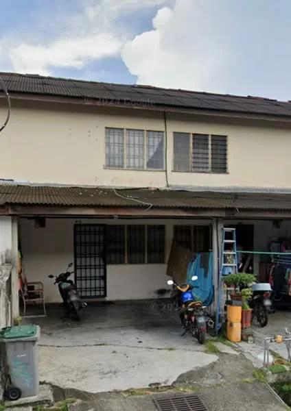 Exterior type: linked terrace house; features: two-storey building, cream painted facade, metal roof, front porch with concrete flooring, gravel driveway, visible parking for motorcycles, window grilles, outdoor storage area, garden pots, ladder, garbage bin; style: traditional.