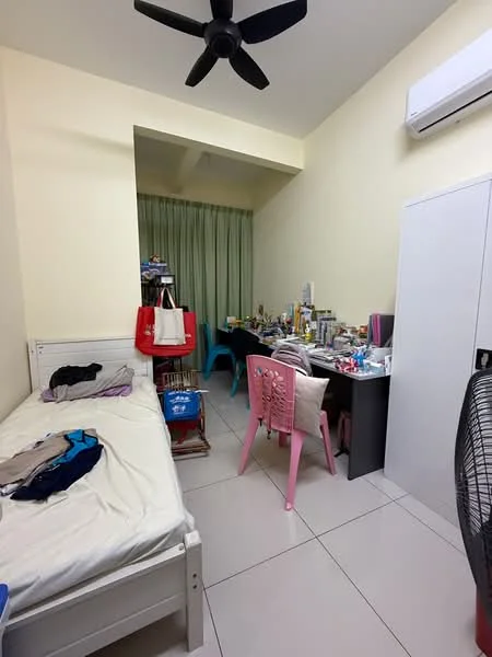 Bedroom features: single bed, white bed frame, light yellow painted walls, ceiling fan, wall-mounted split AC, green curtains, tile flooring, study desk, pink chair, various personal items on desk, clothes on bed, open closet, fan.