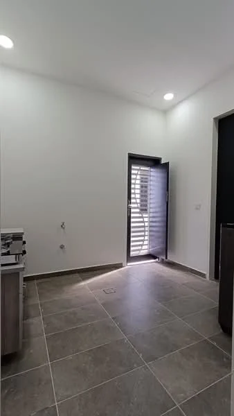 Room features: white painted walls, grey tiled flooring, sliding glass door, black door, recessed downlights, wall-mounted electrical outlets, window with horizontal slats, corner space for furniture; style: modern.
