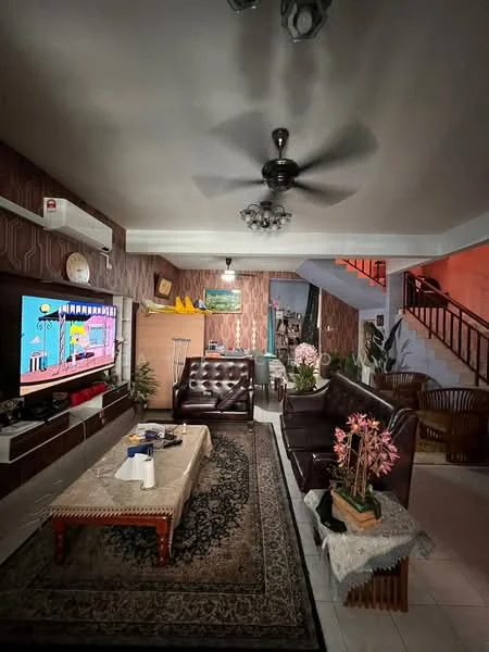 Living features: 3-seater leather sofa in dark brown, 2-seater leather sofa in dark brown, coffee table with wooden legs, area rug with intricate pattern, wall-mounted TV, ceiling fan with light, wall-mounted air conditioning unit, decorative wall clock, framed artwork on wall, potted plants, wooden shelving unit, staircase in background; style: traditional.
