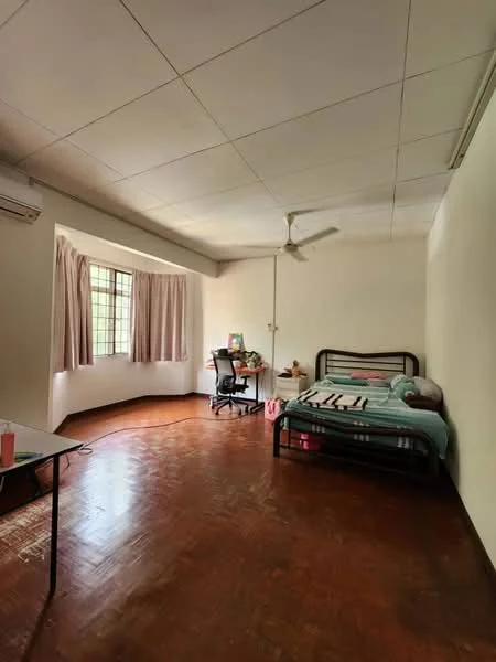 Bedroom features: single bed with bedding, wooden flooring, white painted walls, ceiling fan, window with sheer curtains, study desk with chair, air conditioning unit, decorative items on desk.
