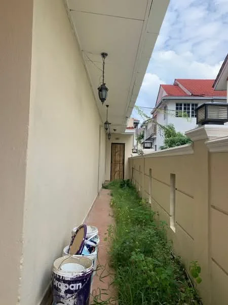 Exterior features: painted walls, overhead lighting fixtures, concrete pathway, overgrown grass, fence, doorway, paint cans.