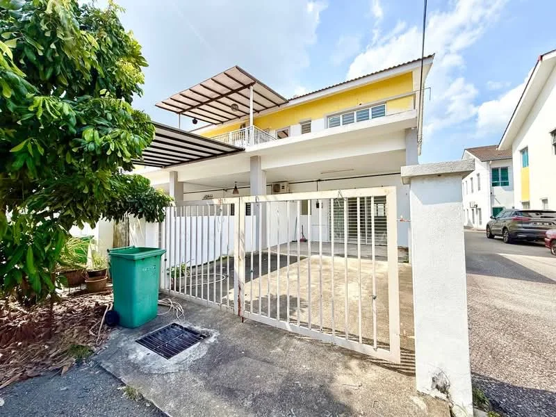Exterior type: semi-detached house; features: yellow painted facade, flat roof with overhang, open terrace on upper level, white railing on terrace, paved driveway, fenced front yard, green trash bin, landscaped garden with plants, single-storey structure, car parked in driveway; style: modern.