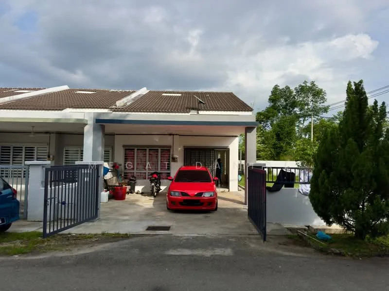 Exterior type: linked terrace house; features: single-storey, red painted facade, pitched tile roof, driveway with interlocking pavers, front gate, manicured lawn, surrounded by greenery, car porch, visible parking area, outdoor clothes drying area; style: modern.