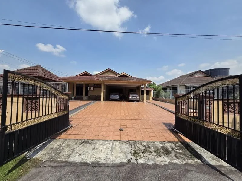 Exterior type: detached bungalow; features: gated entrance with decorative wrought iron gates, paved driveway, two parked cars in car porch, single-storey structure, tiled roof, front porch area, manicured lawn, surrounding fencing, water tank visible on the right, clear blue sky, residential neighborhood context; style: modern.