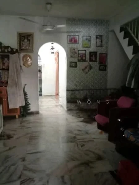 Room features: marble flooring, white painted walls, arched doorway, ceiling fan, wall-mounted artwork, decorative wall with patterned wallpaper, sofa in dark color, wooden cabinet, hanging clothes visible, photo frames on wall.