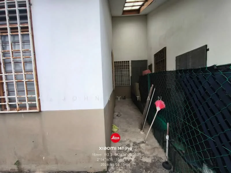 Exterior features: white painted walls, concrete flooring, metal grilles on windows, fenced area, outdoor space, storage area, visible cleaning tools, adjacent wall, roof overhang.