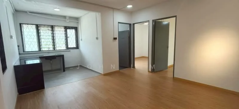 Room features: white painted walls, laminate flooring, large window with metal grille, ceiling lights, doorway leading to other rooms, desk area, neutral color scheme; style: modern.