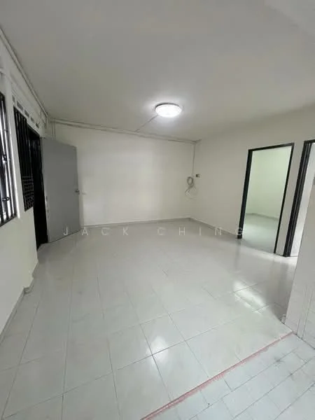 Room features: white painted walls, white ceiling, fluorescent ceiling light, tiled flooring, corner wall with electrical outlet, doorway leading to another room, doorway leading to hallway, window with metal grille; style: minimalist.
