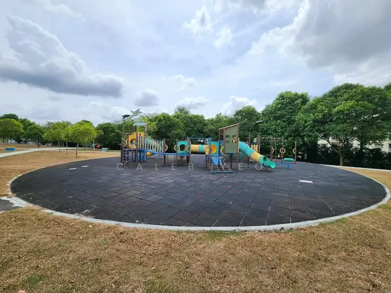 Exterior type: children's playground; features: playground equipment with slides, climbing structures, swing sets, rubberized flooring, surrounding grass area, trees providing shade, benches for seating, open space for activities; style: modern.