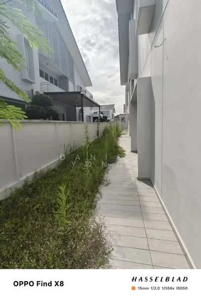 Exterior features: paved walkway, overgrown grass, white painted walls, fence, cloudy sky, adjacent building; style: modern.