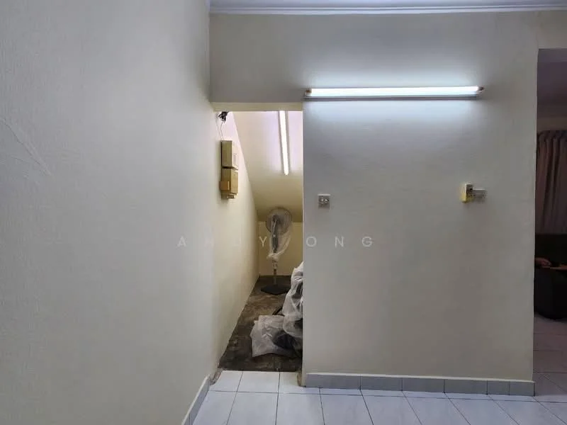 Room features: white painted walls, tile flooring, fluorescent ceiling lights, wall-mounted electrical outlet, fan, corner with visible clutter.