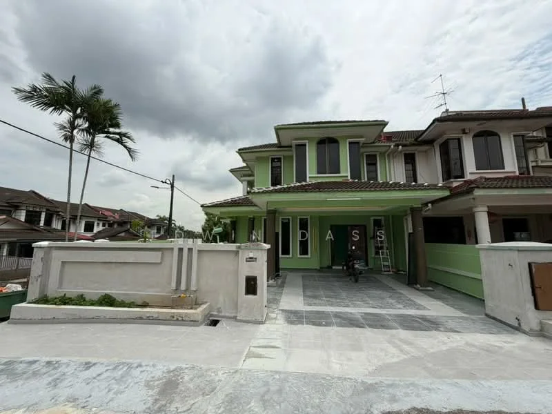 Exterior type: semi-detached house; features: green painted facade, flat roof, two-storey structure, manicured lawn, paved driveway, front porch, balcony on upper floor, surrounded by palm trees, visible neighboring houses; style: modern.