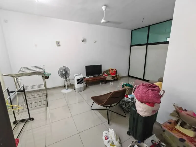 Living features: white painted walls, tile flooring, ceiling fan, wall-mounted TV, folding chair, clothes drying rack, air conditioning unit, green sliding glass door, various bags and items on the floor.