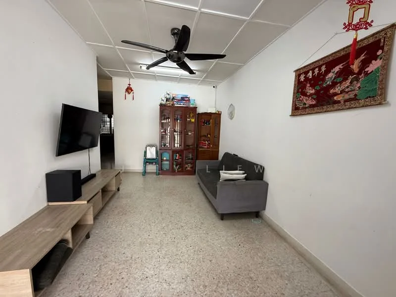 Living features: grey fabric sofa, 3-blade ceiling fan, wall-mounted TV, TV console, wooden shelving unit, decorative wall hanging, light-colored tiled flooring, white painted walls, window with natural light, small round wall clock; style: minimalist.