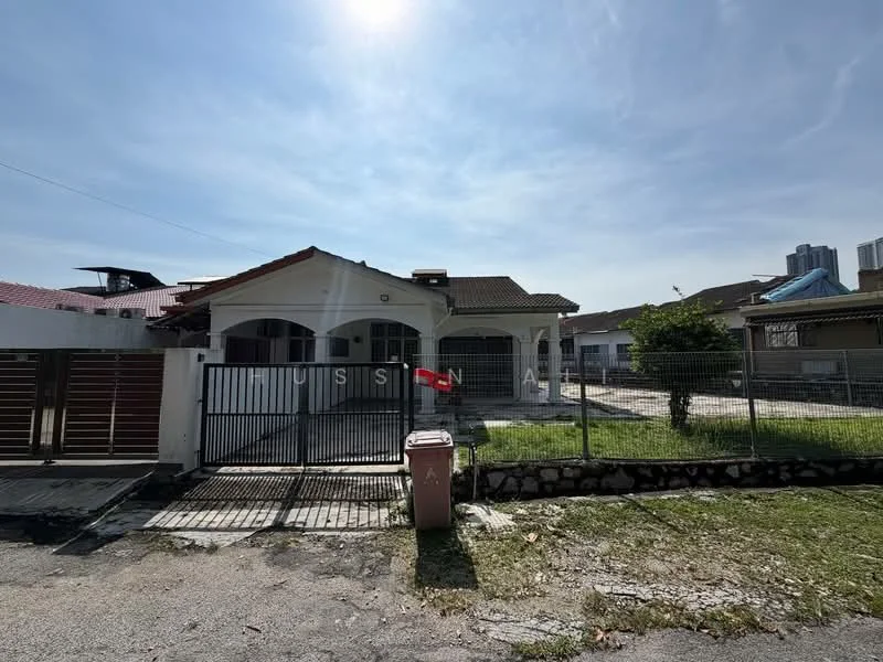 Exterior type: detached bungalow; features: white painted facade, pitched tile roof, single-storey, manicured lawn, fenced yard, driveway with interlocking pavers, front porch, garden area, visible neighboring buildings, clear blue sky; style: modern.