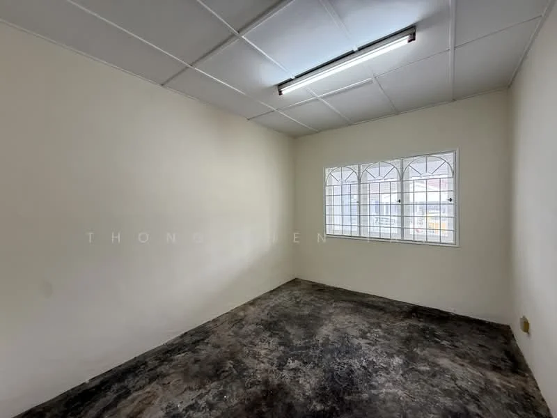 Room features: white painted walls, plain ceiling, fluorescent light fixture, window with grid pattern, concrete flooring, no visible furniture, empty space; style: minimalist.