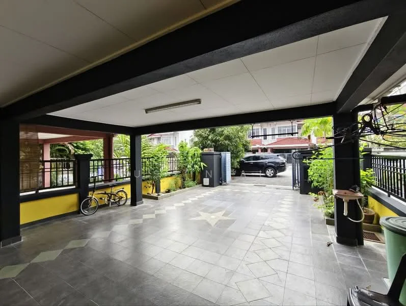 Exterior type: car porch; features: covered car porch, grey tiled flooring, yellow painted walls, black structural beams, landscaped greenery, bicycle parked, perimeter fence, driveway, outdoor lighting, visible car, manicured plants; style: modern.