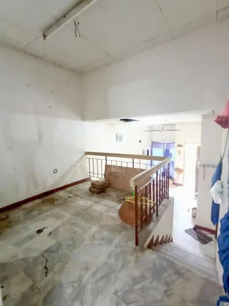 Room features: marble flooring, white painted walls, wooden railing, staircase, ceiling with fluorescent lights, open space, natural light from windows, unfinished appearance.
