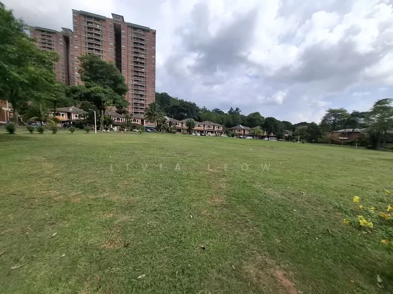 Exterior type: high-rise condominium; features: green lawn, mature trees, surrounding residential buildings, open grassy area, urban landscape, cloudy sky; style: modern.