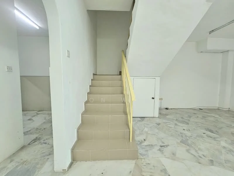 Room features: marble flooring, white painted walls, staircase with yellow railing, built-in storage cabinet under stairs, ceiling with fluorescent lighting; style: minimalist.