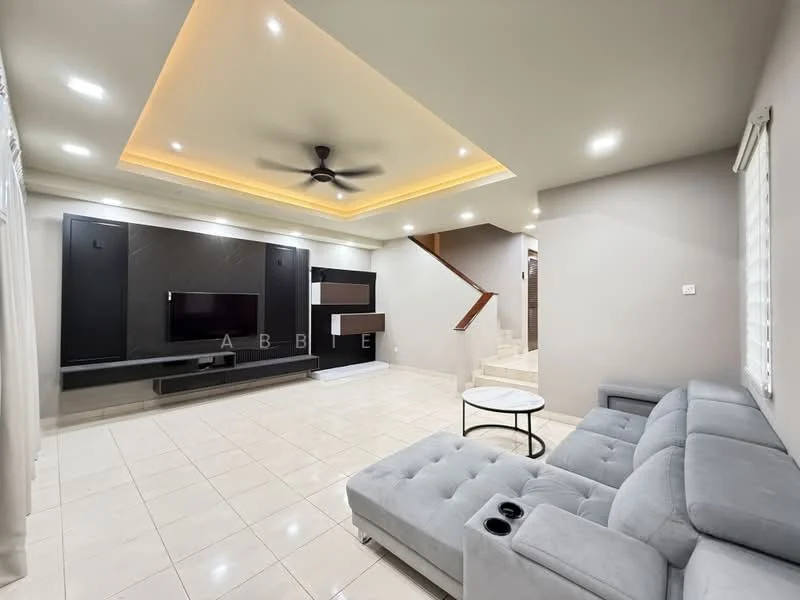 Living features: grey fabric sectional sofa with cup holders, white round coffee table, wall-mounted TV, black entertainment unit, recessed LED downlights, tray ceiling with ambient lighting, cream painted walls, glossy tile flooring, ceiling fan, staircase leading to upper floor; style: modern.