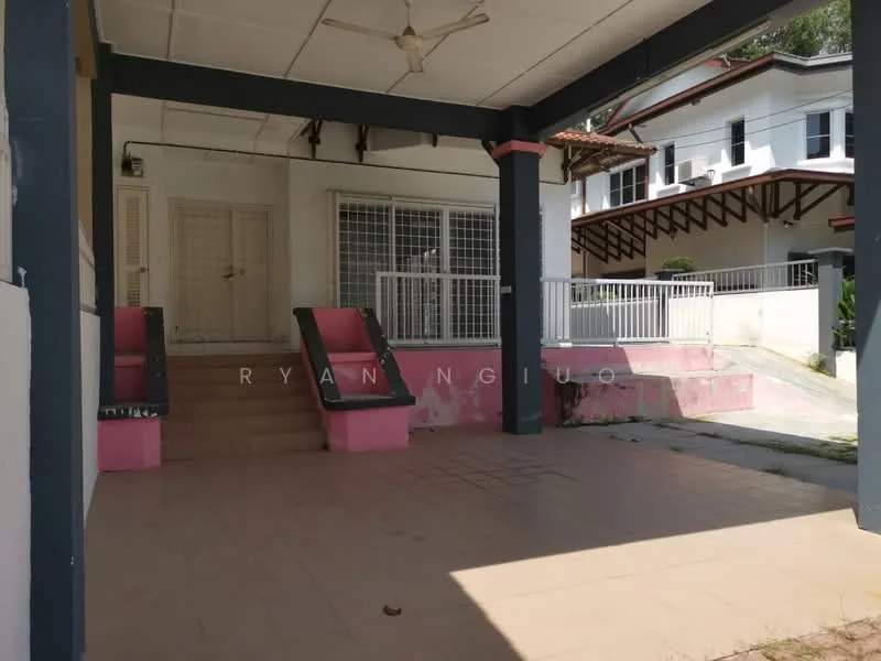 Exterior type: detached bungalow; features: covered porch, staircase leading to entrance, pink and grey exterior walls, sliding metal gate, manicured lawn, paved walkway, surrounding greenery, two-storey house in background, gabled roof, balcony on upper floor; style: modern.
