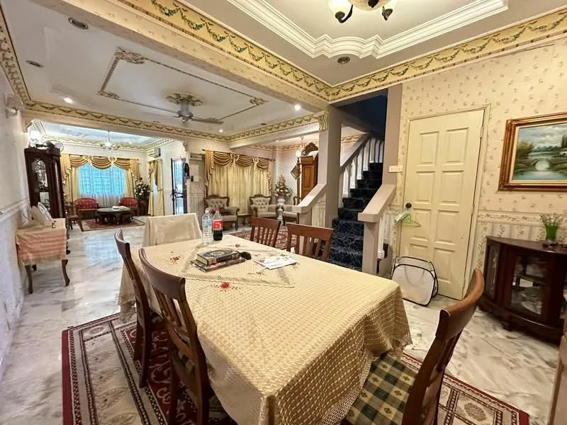 Dining features: marble flooring, decorative ceiling with crown moulding, 6-seater wooden dining table, upholstered dining chairs, tablecloth with floral pattern, framed artwork on wall, wall-mounted light fixture, carpet with intricate pattern; style: traditional. Living features: sofa set with cushions, coffee table, curtains with floral pattern, wall-mounted TV, decorative side table, wooden cabinet, area rug, ceiling fan; style: traditional. Hallway features: staircase with carpet runner, decorative wall paneling, door leading to other rooms, light fixture, wall decor; style: traditional.