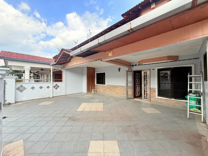 Exterior type: semi-detached house; features: flat roof, cream painted facade, grey tiled flooring, exposed brick accents, main entrance door with decorative design, open outdoor space, surrounded by low fencing, manicured landscaping, outdoor utility area, multiple windows for natural light, covered porch area; style: modern.