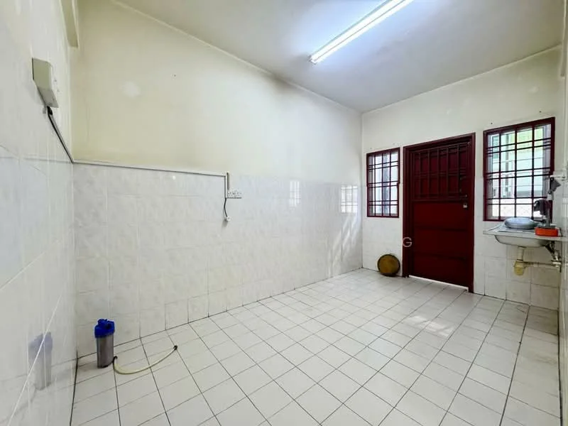 Kitchen features: white tiled walls, white tiled flooring, single-bowl stainless-steel sink, chrome faucet, red door, two windows with metal grills, wall-mounted electrical outlet, empty space for appliances.