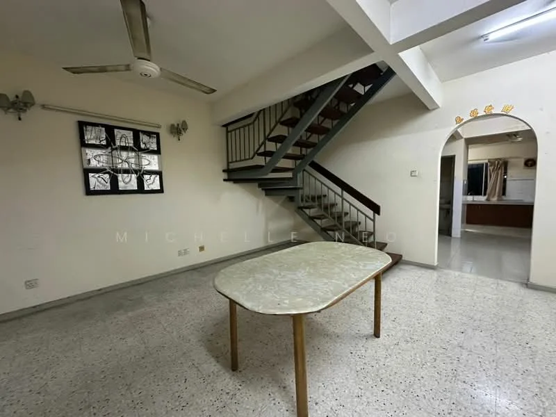 Living features: ceiling fan, table with marble top, staircase with wooden railing, exposed concrete flooring, white painted walls, wall-mounted light fixtures, arched doorway leading to kitchen, window with decorative grille. Kitchen features: open layout, kitchen area visible through archway, unknown appliances.
