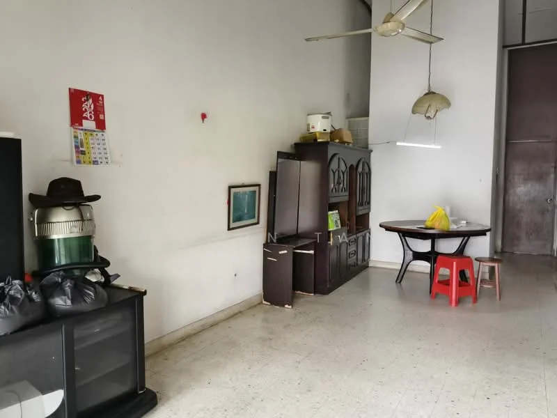 Room features: white painted walls, tile flooring, ceiling fan, wooden dining table, red plastic chair, black cabinet, green cabinet, framed artwork, hanging light fixture, calendar on wall, black storage unit, hat on cabinet.