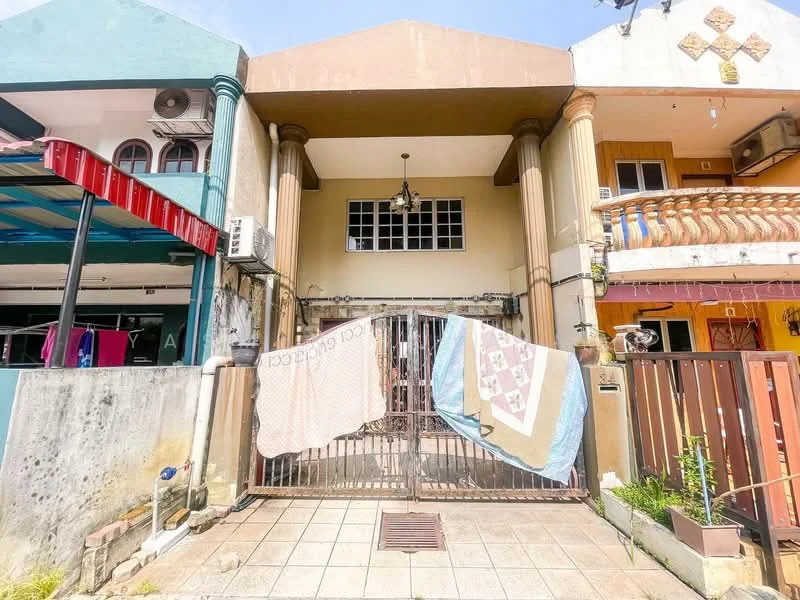 Exterior type: linked terrace house; features: two-storey facade, cream painted facade, columns at entrance, gated entrance, tiled walkway, balcony on upper floor, decorative elements on facade, air conditioning unit visible, laundry hanging in front; style: traditional.