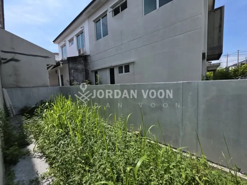 Exterior features: two-storey building, concrete wall, overgrown grass, clear blue sky, adjacent building, residential area.