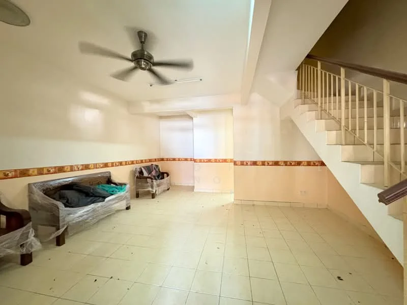 Living features: cream painted walls, white ceiling, 5-blade ceiling fan, tiled flooring, staircase leading to upper floor, two-seater sofa wrapped in plastic, decorative wall border, natural light from window, open layout.