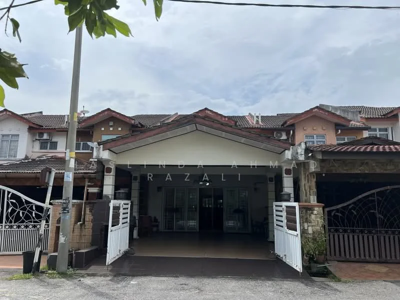 Exterior type: linked terrace house; features: white painted facade, red tiled roof, double-volume main entrance, porch area with interlocking pavers, decorative wrought iron gate, surrounded by greenery, two-storey structure, visible windows with grilles, front garden area; style: modern.