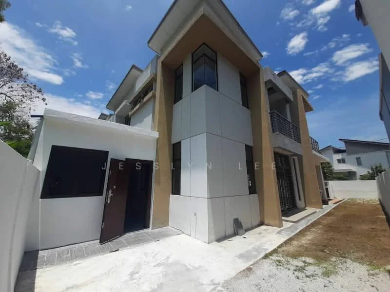 Exterior type: detached bungalow; features: two-storey building, cream painted facade, grey stone cladding, balconies with black railings, flat roof, manicured lawn, paved walkway, surrounded by white fencing, clear blue sky, landscaped garden area; style: modern.