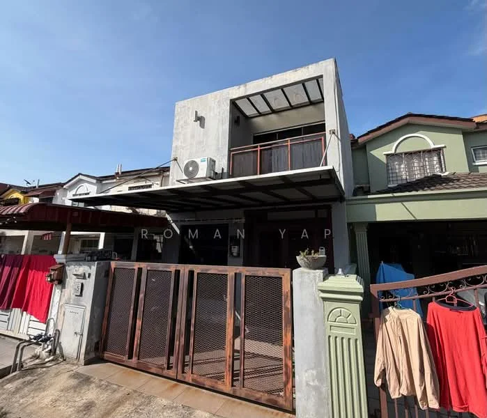 Exterior type: semi-detached house; features: grey concrete facade, flat roof, two-storey structure, metal gate, balcony with railing, air conditioning unit visible, manicured front yard, clothes hanging on lines, driveway, surrounded by other residential buildings; style: modern.