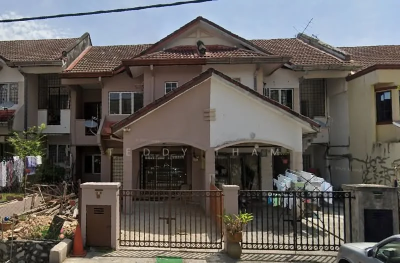 Exterior type: linked terrace house; features: two-storey building, red tiled roof, cream painted facade, front gate with metal grille, driveway with interlocking pavers, laundry hanging in front yard, garden area with stones, windows with security bars, balcony on upper floor, visible antenna on roof; style: modern.