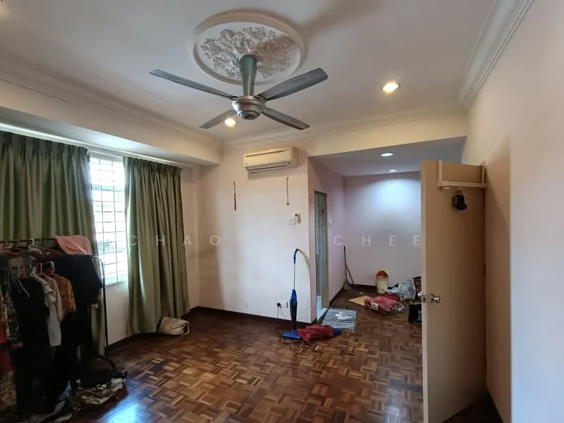 Room features: wooden flooring, white painted walls, crown moulding, 5-blade ceiling fan with light, wall-mounted split AC, floor-to-ceiling window with green curtains, door leading to another room, clothes rack with hanging clothes, vacuum cleaner, decorative ceiling rose.