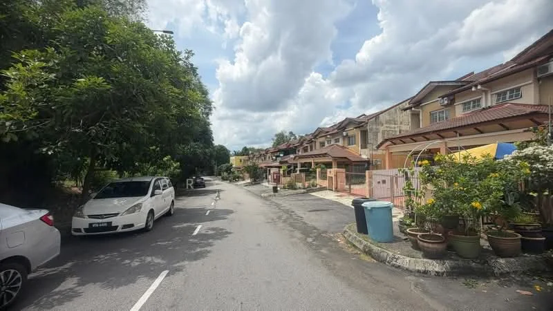 Exterior type: linked terrace house; features: two-storey linked terrace houses, paved driveway, manicured gardens, mature trees lining the street, street parking, sidewalk, cloudy sky, residential neighborhood; style: modern.